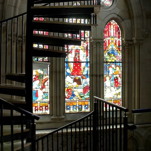 Spiral UK stair backlit by stained glass window