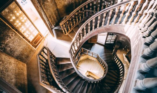 Looking down on the spiral staircase inside the derelict palace, with graffiti on the walls